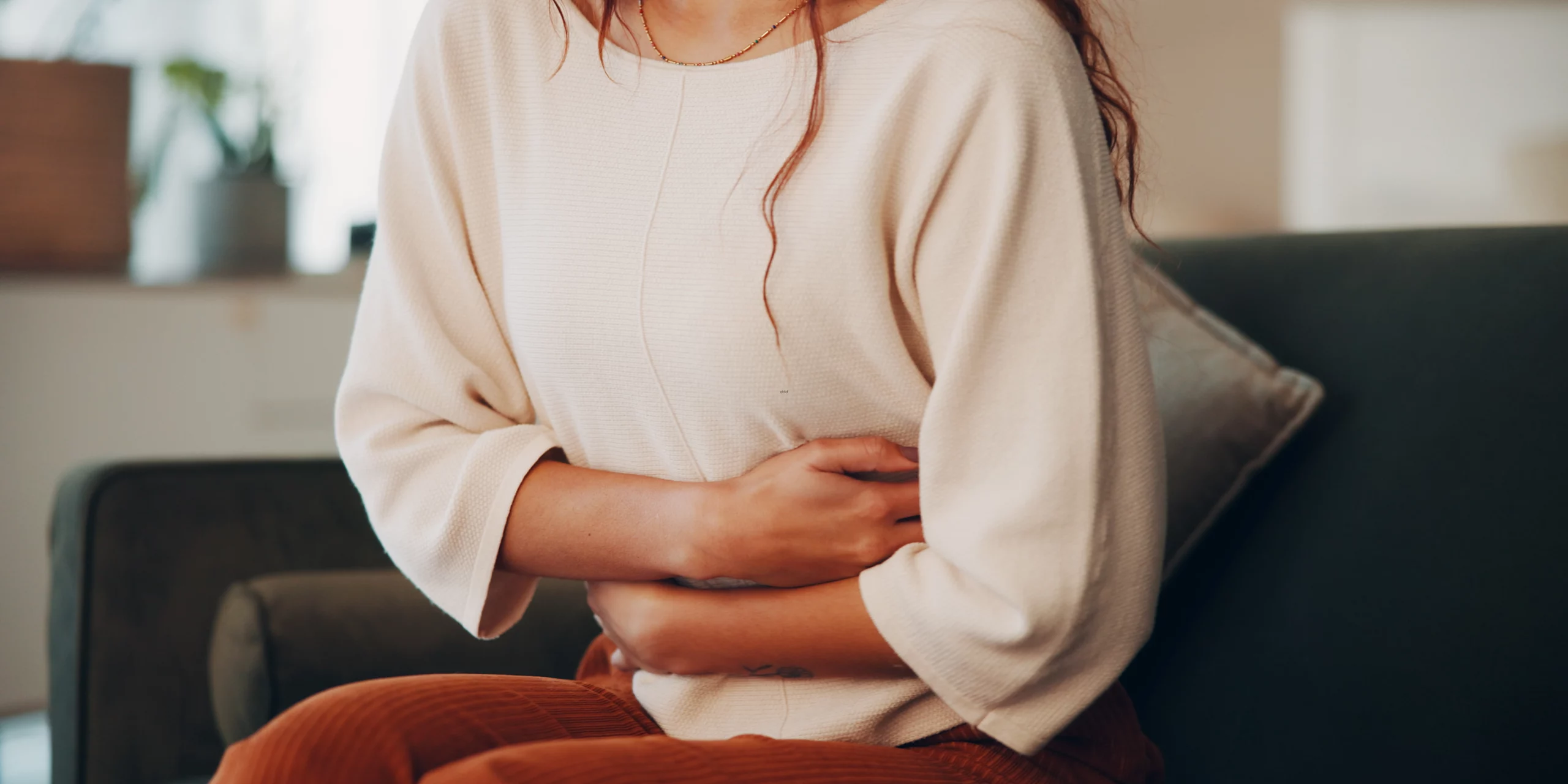 Femme tenant son ventre à cause de ses douleurs.